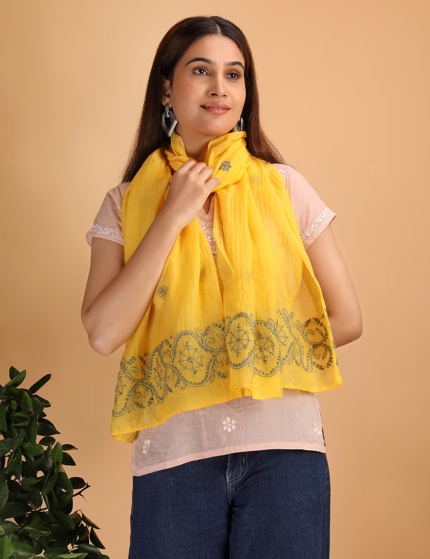 Woman wearing a yellow scarf with blue patterns on a beige background