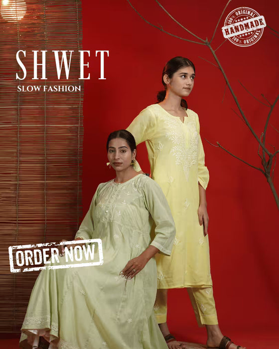 Two women in traditional attire with hand embroidery, sitting close together.