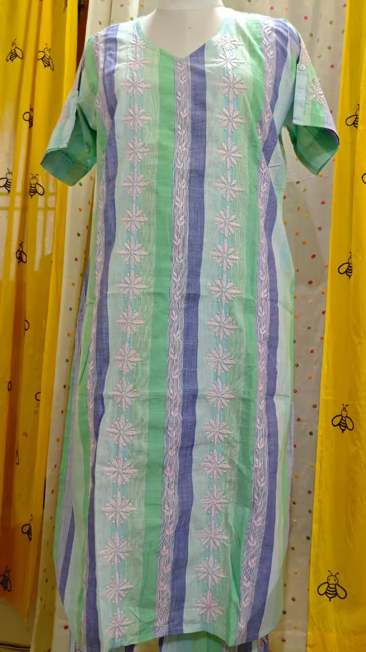 Green and purple striped dress with Chikankari patterns on a mannequin against a yellow curtain background.