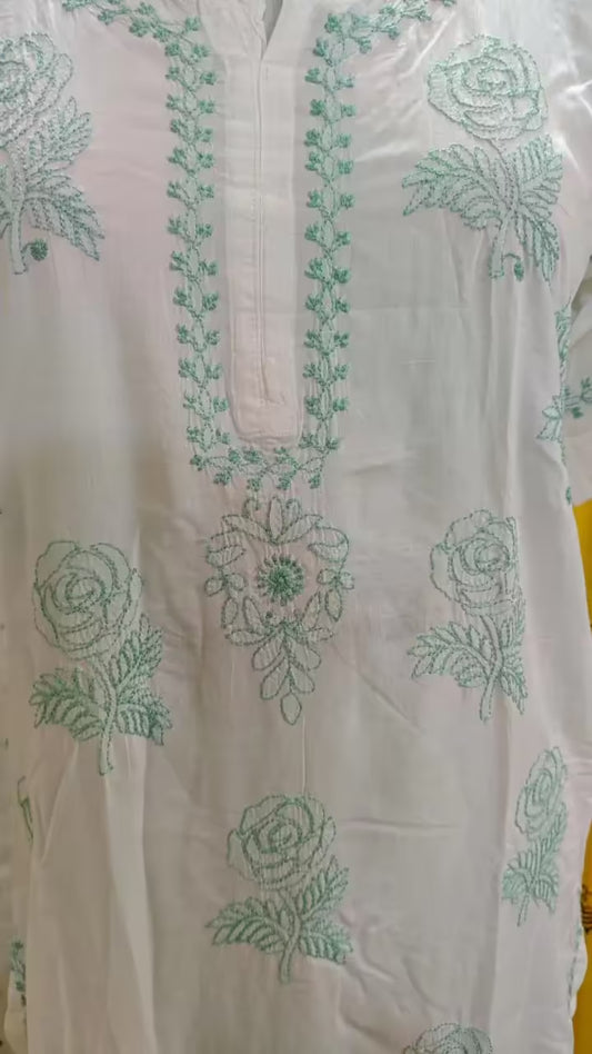 White fabric with green Chikankari embroidery on a clear background