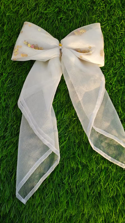 Large decorative bow with sheer fabric on a grass background