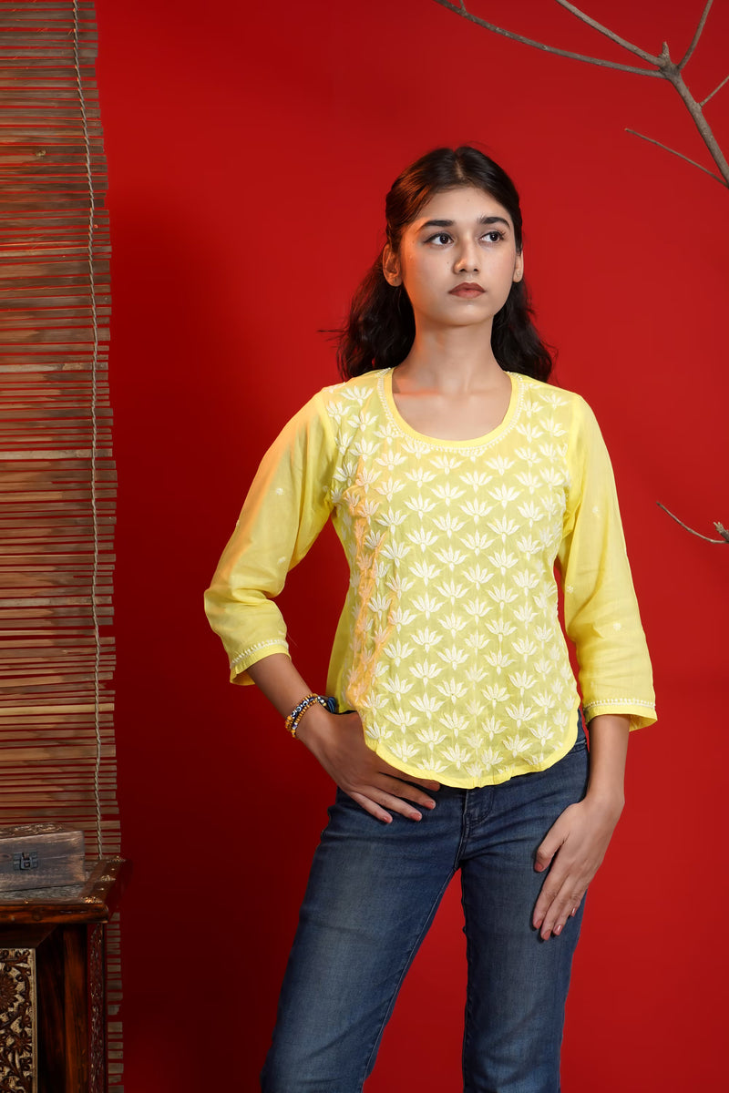 The model is wearing a yellow and white handmade chikankari top with a red background