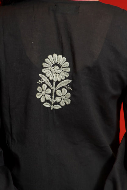 Black fabric with white floral embroidery on a red background