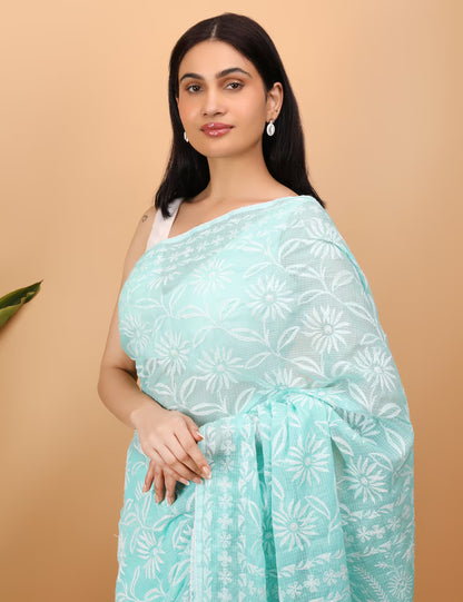 Woman wearing a light blue saree with white Chikankari  patterns on a beige background
