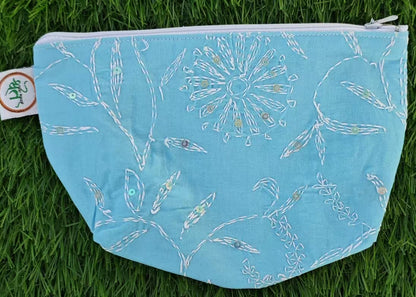 Blue pouch with white floral pattern on grass