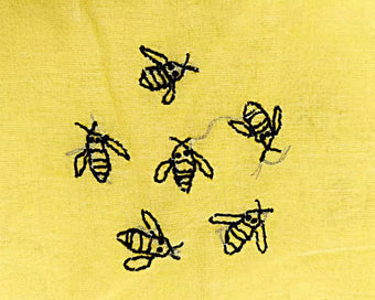 Chikankari Black embroidered bees on a yellow fabric background