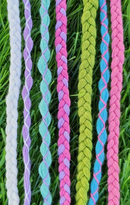 Colorful braided ropes on a grass background