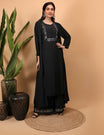 Woman wearing a black Kurti Plazzo Shrug Set with embroidery standing against a beige background