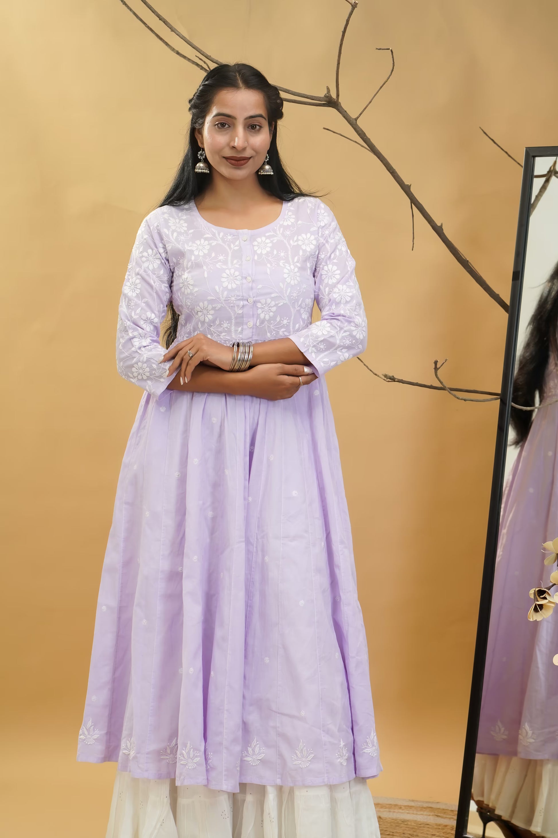 Woman wearing a light purple dress with a beige background