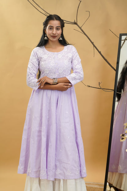 Woman wearing a light purple dress with a beige background