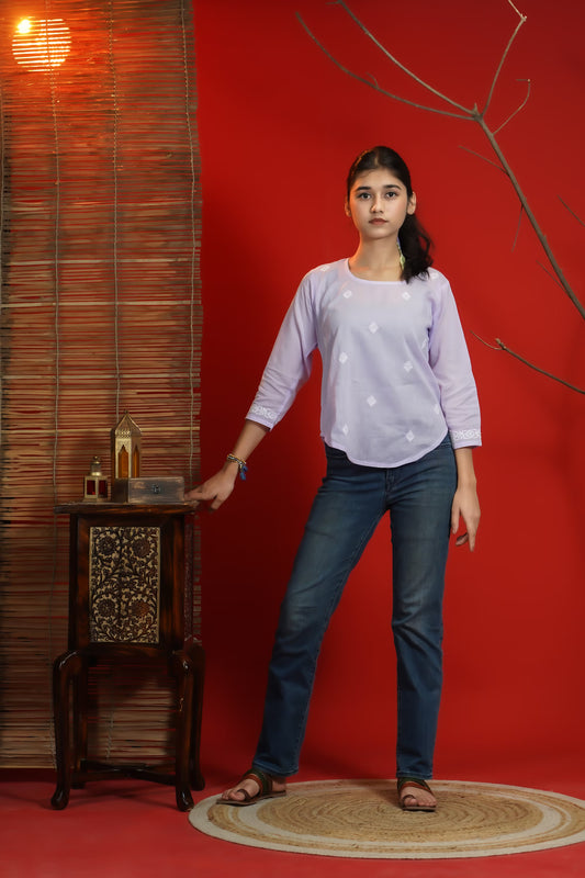 Woman standing in a room with a red wall and wooden furniture.