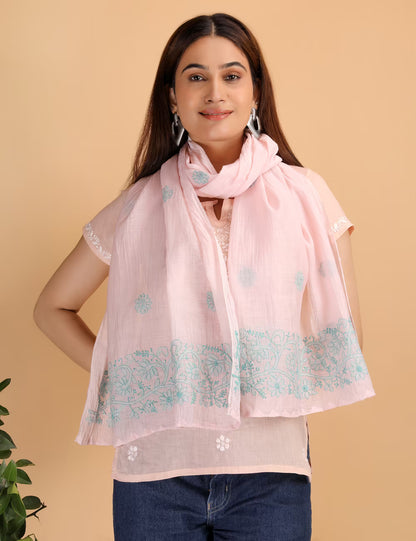 Woman wearing a pink scarf with  chikankari patterns on a beige background
