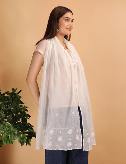 Woman wearing a nude colour  scarf with chikankari patterns on a beige background