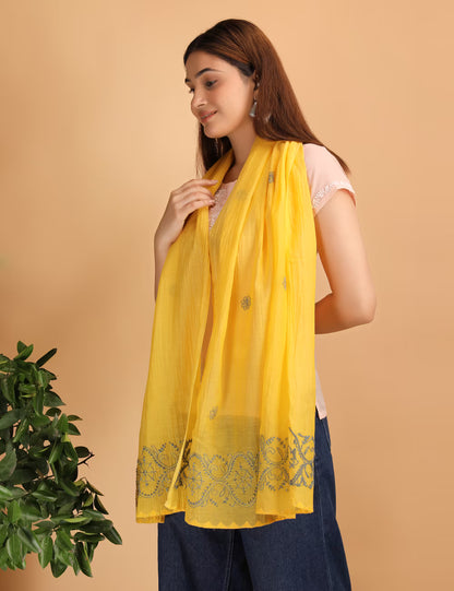 Woman wearing a yellow scarf with  hand embroidered chikankari patterns on a beige background