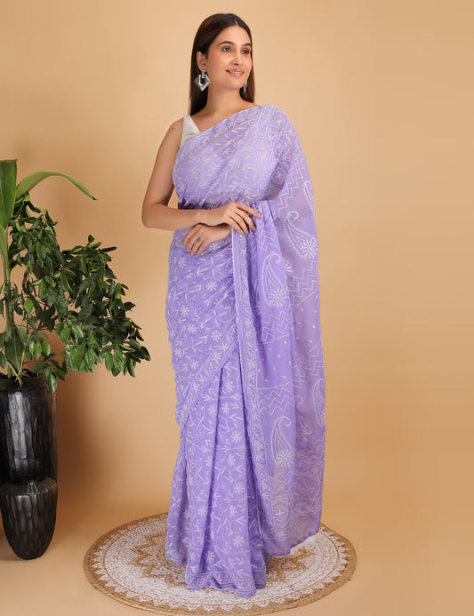 Woman wearing a purple  Chikankari saree with a white  Hand Embroidered pattern on a beige background