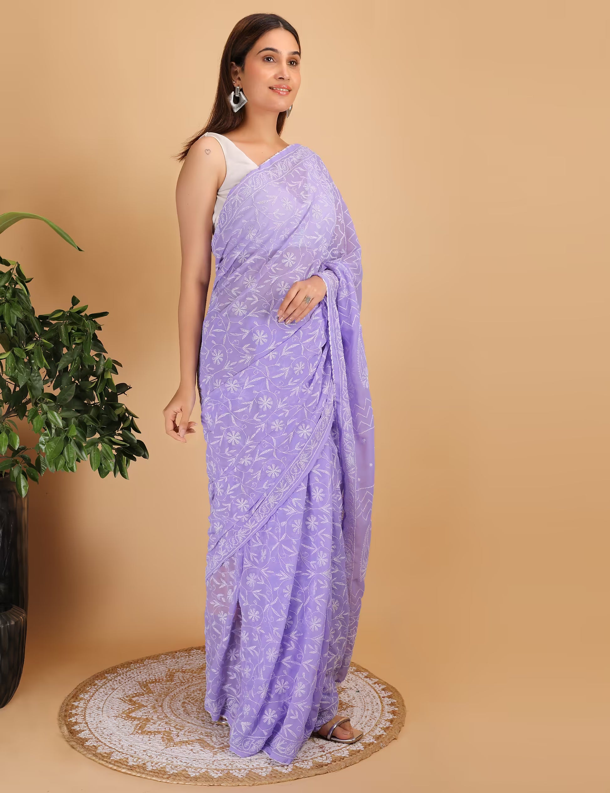 Woman wearing a purple  Chikankari saree with a white background