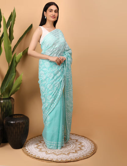 Woman wearing a light blue saree with white  Chikankari patterns on a beige background