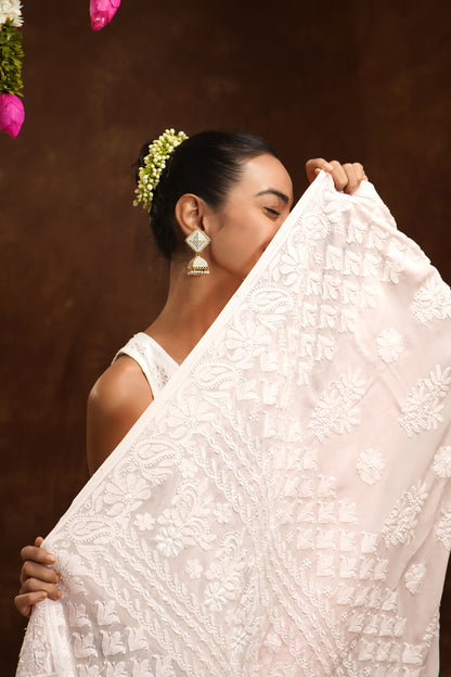 Woman holding a white embroidered fabric against a brown background