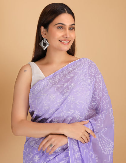 Woman wearing a light purple  Chikankari saree with white patterns on a beige background