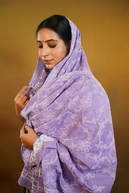Woman wearing a purple embroidered  Dupatta against a brown background