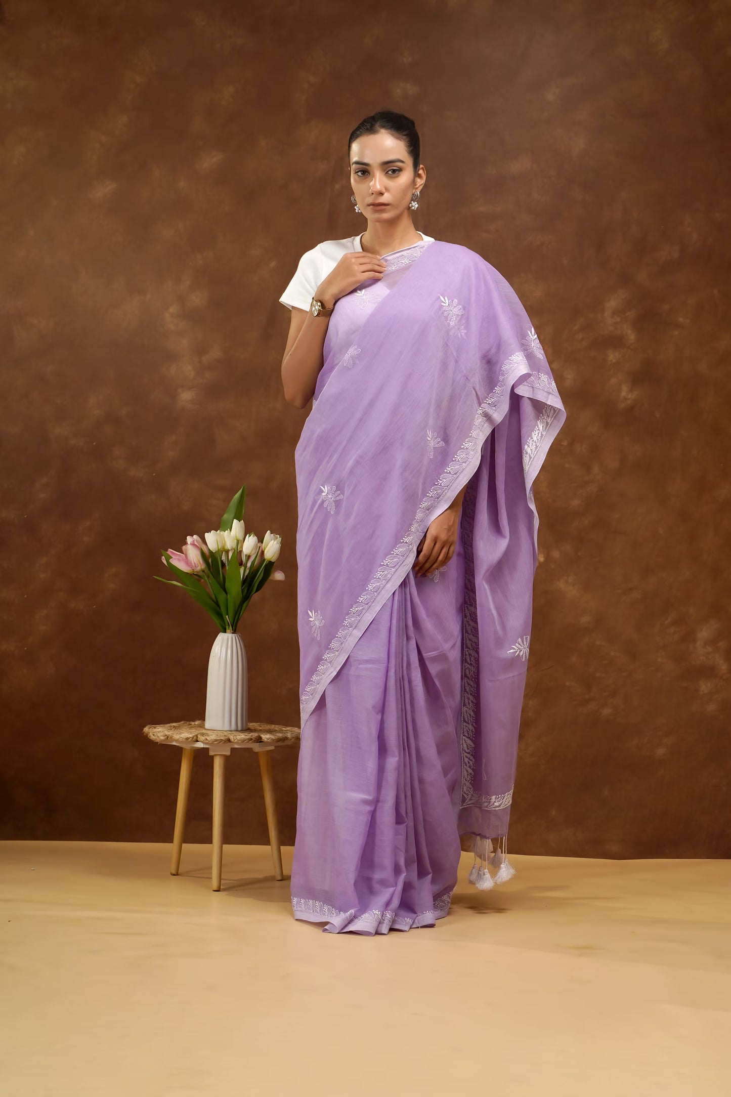 Woman wearing a purple saree with a white background