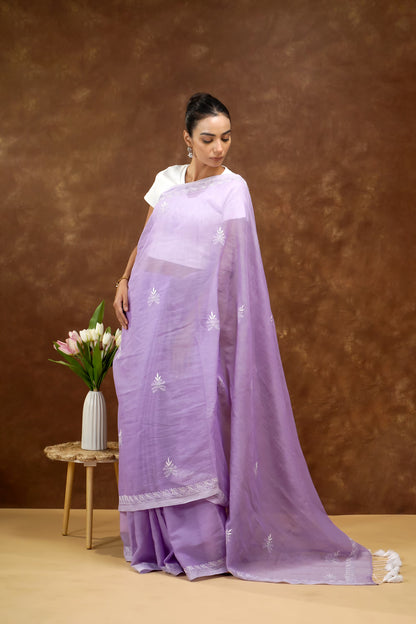 Woman wearing a lavender saree with a brown background