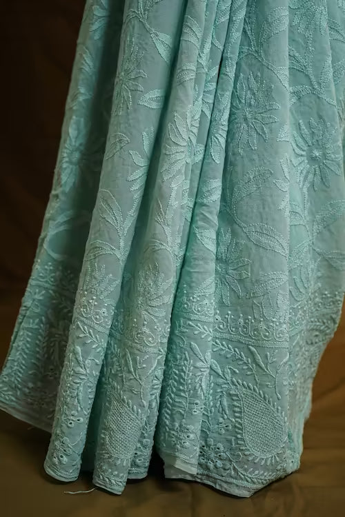 Teal textured fabric with a floral pattern on a brown background