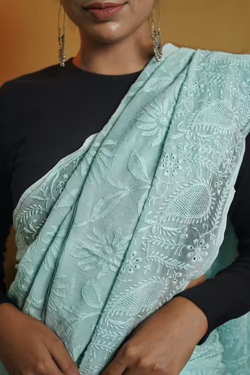 Woman wearing a light blue embroidered scarf with a blurred background
