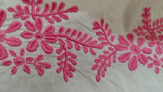 Close-up of pink Chikankari  embroidery on white fabric