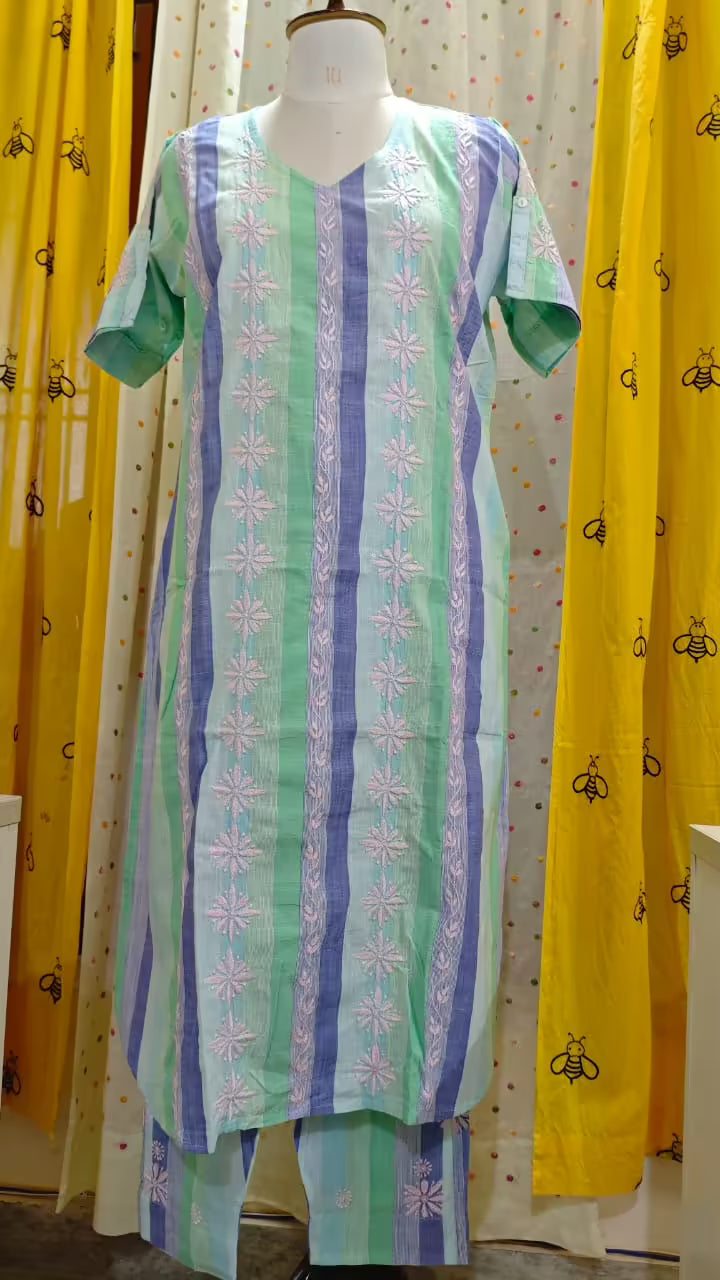 Mannequin wearing a  Chikankari patterned dress with yellow curtains in the background