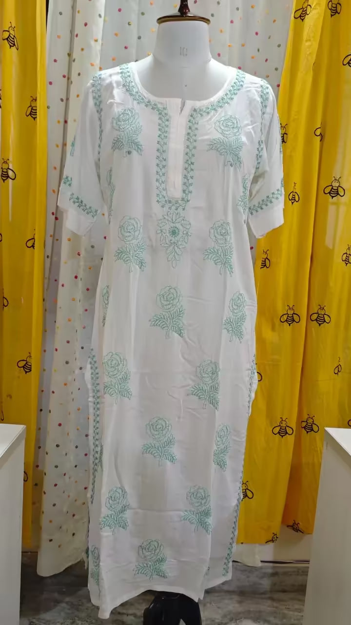 White Hand embroidered Chikankari  kurta on a mannequin with yellow curtains in the background