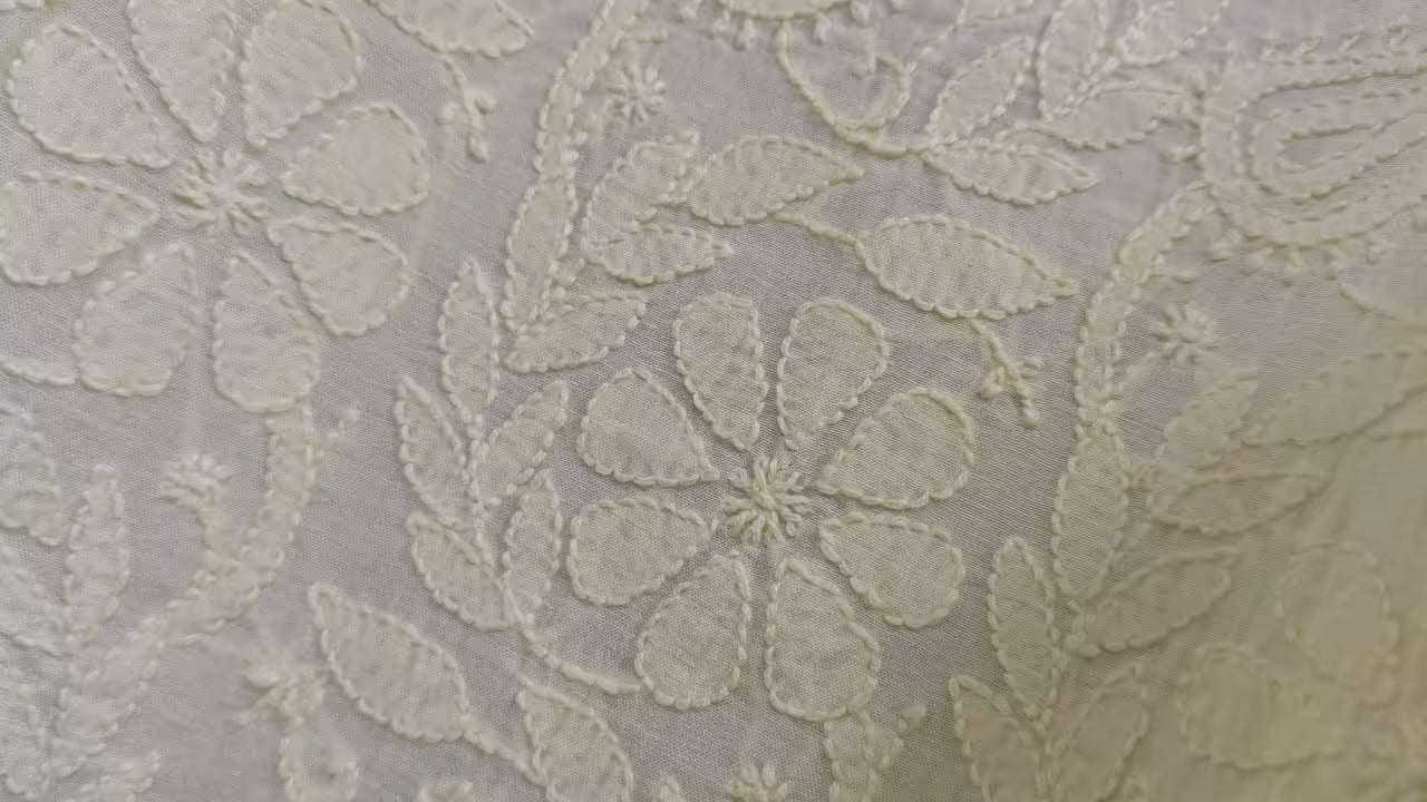 Chikankari  patterned fabric with light   flowers on a gray background