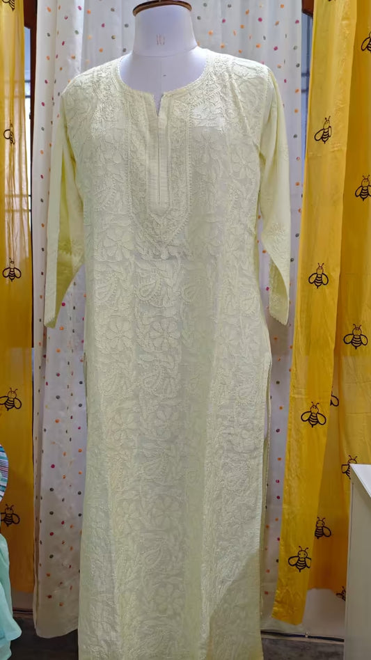 Light Yellow  embroidered  Chikankari dress on a mannequin against a yellow curtain with black bee pattern