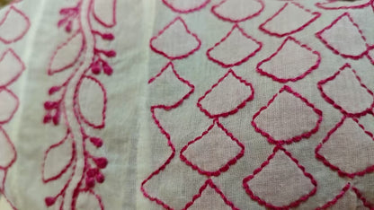 Close-up of fabric with red  Chikankari embroidery on a white background