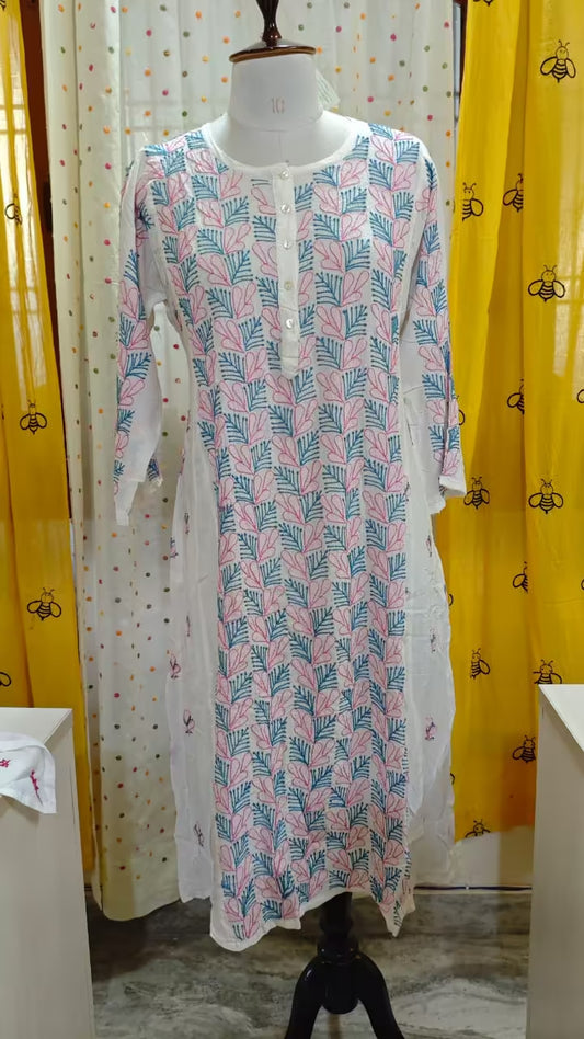 Long patterned  Chikankari dress on a mannequin against a colorful curtain background