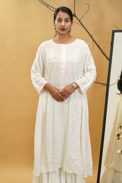 Woman wearing a white traditional outfit against a beige background