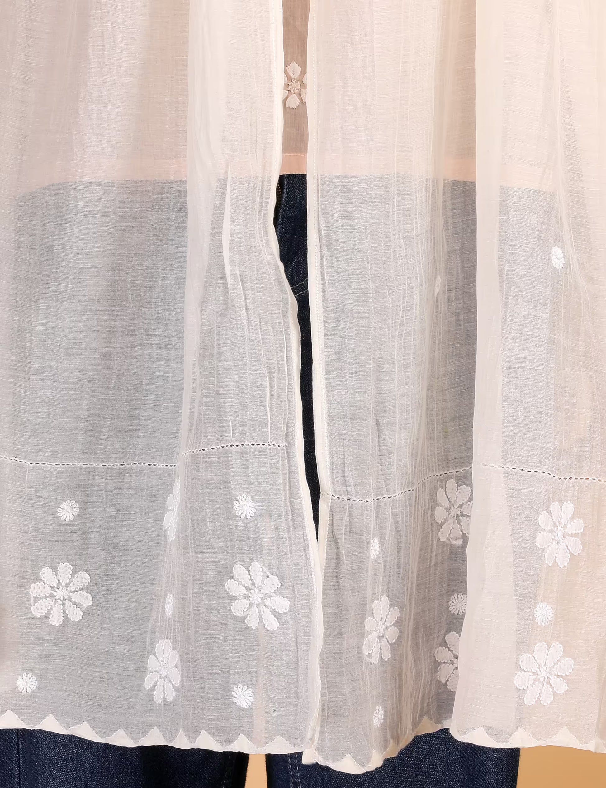 Sheer white Stole with floral embroidery on a beige background