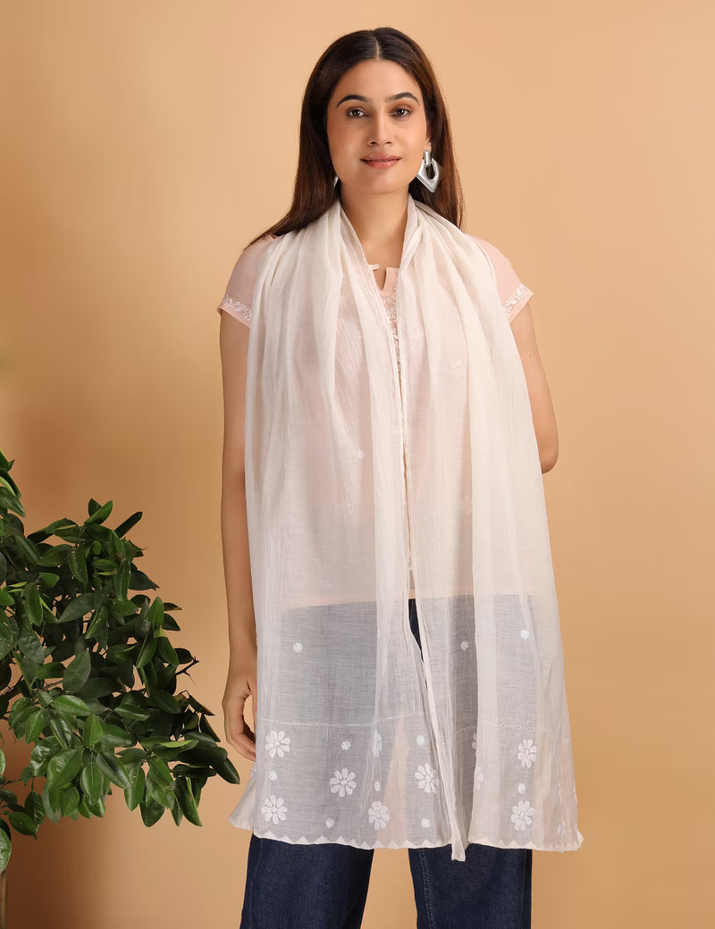 Woman wearing a white scarf with  Chikankari patterns on a beige background
