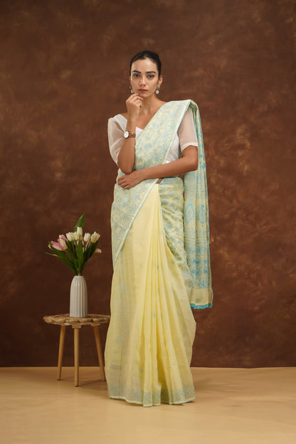 Woman wearing a yellow and blue saree with a brown background