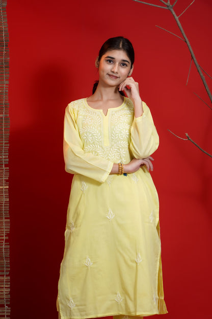 Woman wearing a yellow embroidered dress against a red background