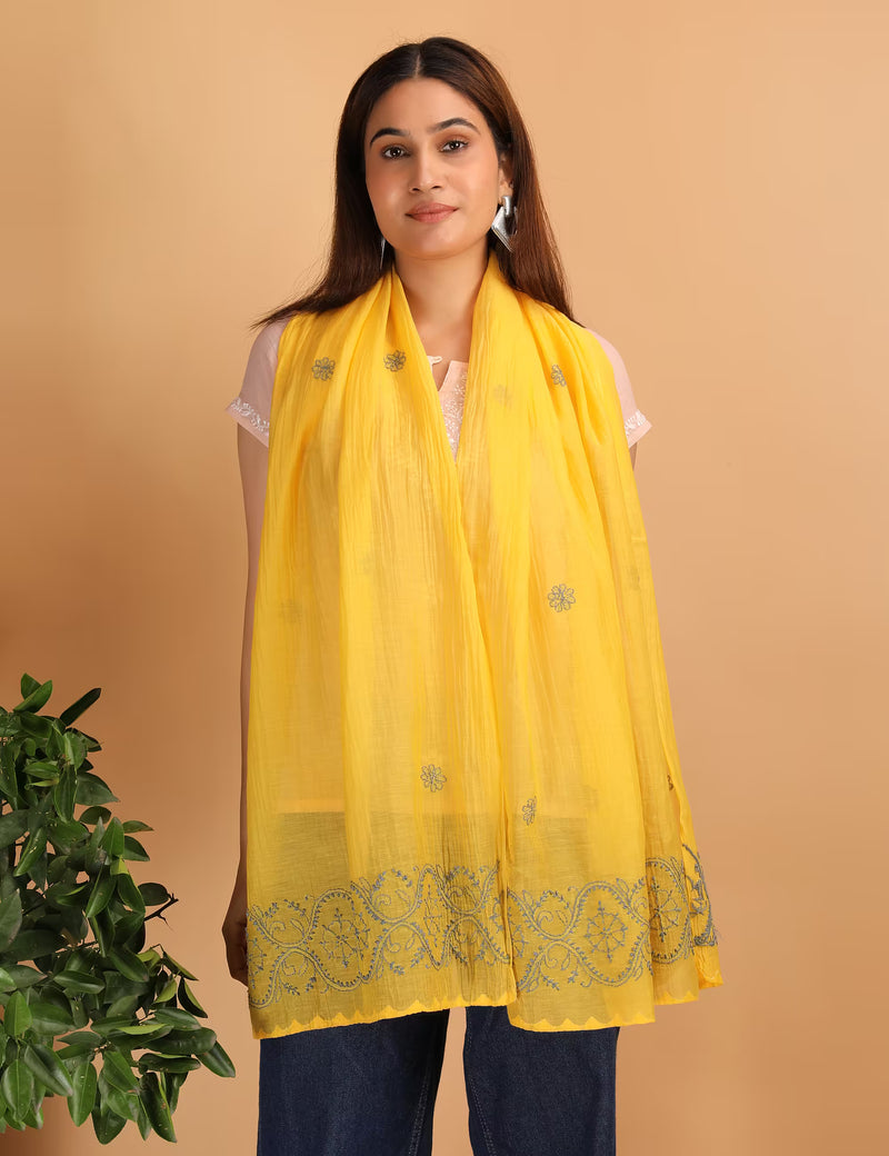 Woman wearing a yellow scarf with intricate Chikankari patterns on a beige background