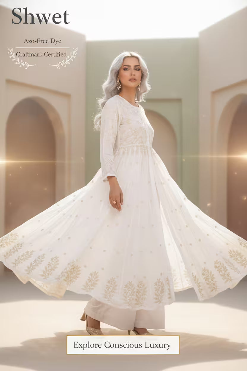 Woman wearing a white  Chikankari dress with gold embroidery in an architectural setting.