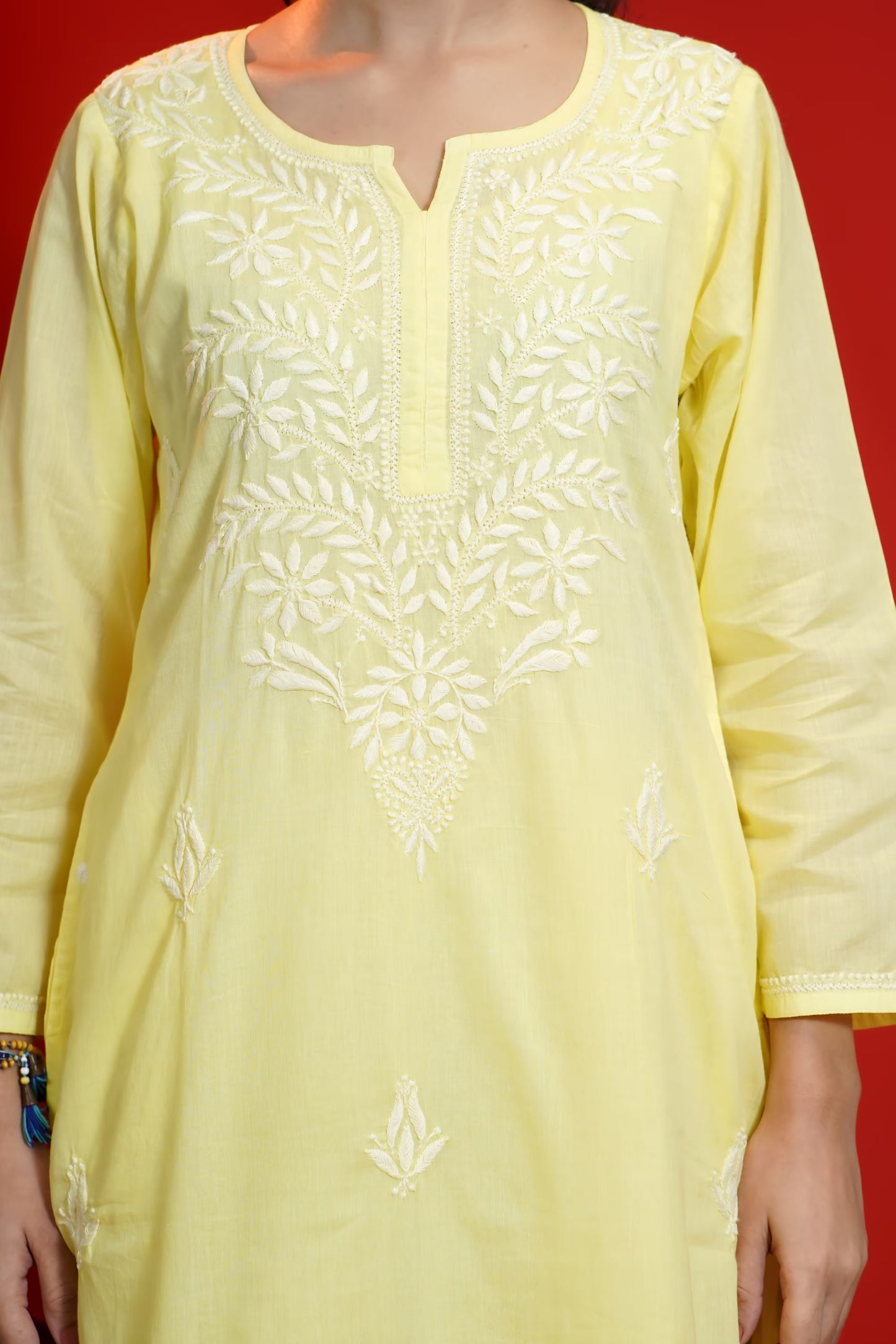 Yellow kurta with white embroidery on a red background
